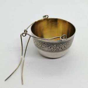 Passe-thé en argent avec frise décorative sur fond guilloché, 1920.